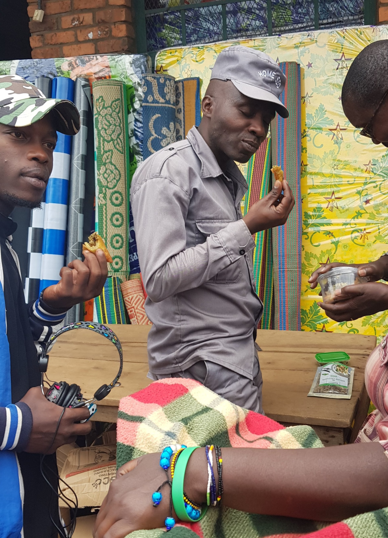 Two men in Rwanda are enjoying the fried cricket food.