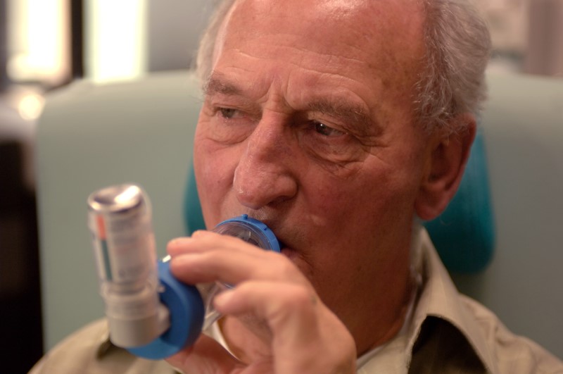 Een COPD-patient neemt een puf om zijn luchtwegen te verwijden.