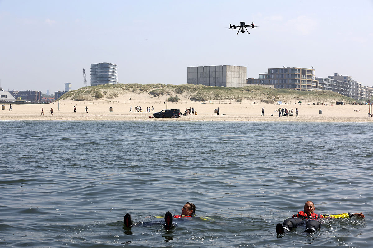 Drone flying above the sea and beach with swimming lifeguards