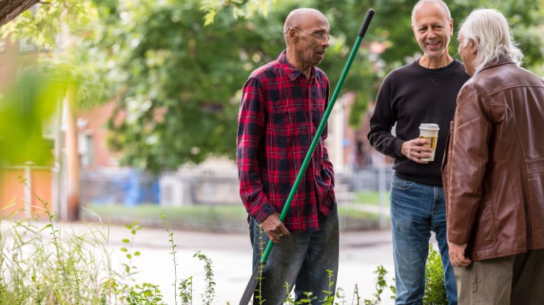 Senioren buren met elkaar in gesprek op straat