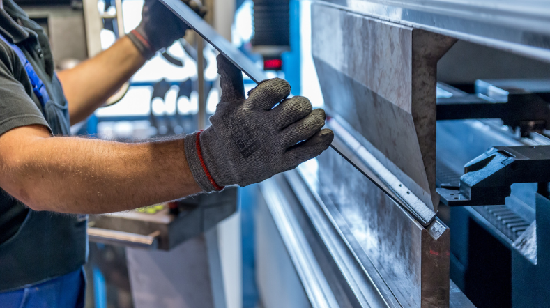 Man die metalen plaat vasthoudt in bewerkmachine.