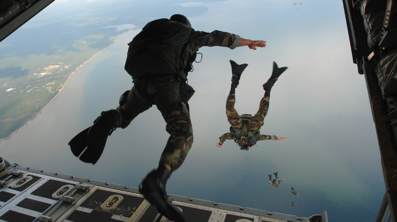 Twee soldaten die uit een helicopter springen.